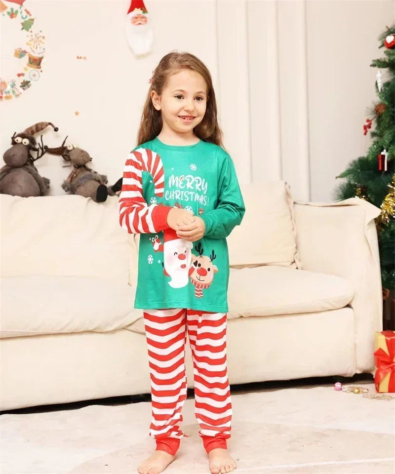 Family wearing matching candy cane pyjamas, enjoying a warm holiday moment by the fire.