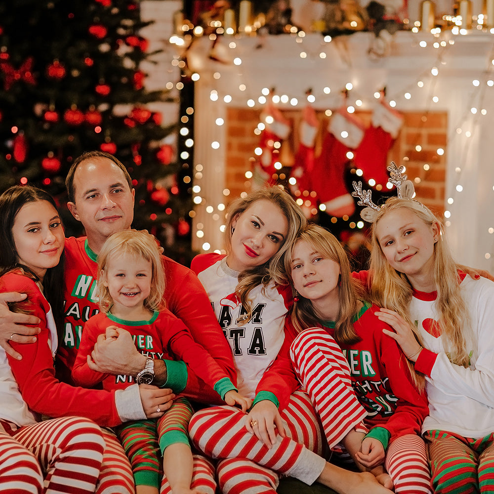 Family wearing matching pyjamas in front of xmas decorations